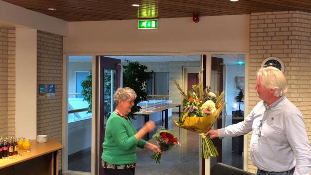 Henk Vinke geeft Netty Rutz bloemen bij haar benoeming tot commissielid