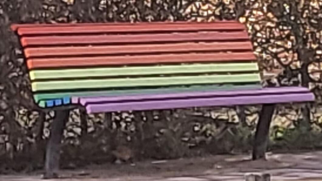 Bankje in regenboogkleuren bij school De Vonk
